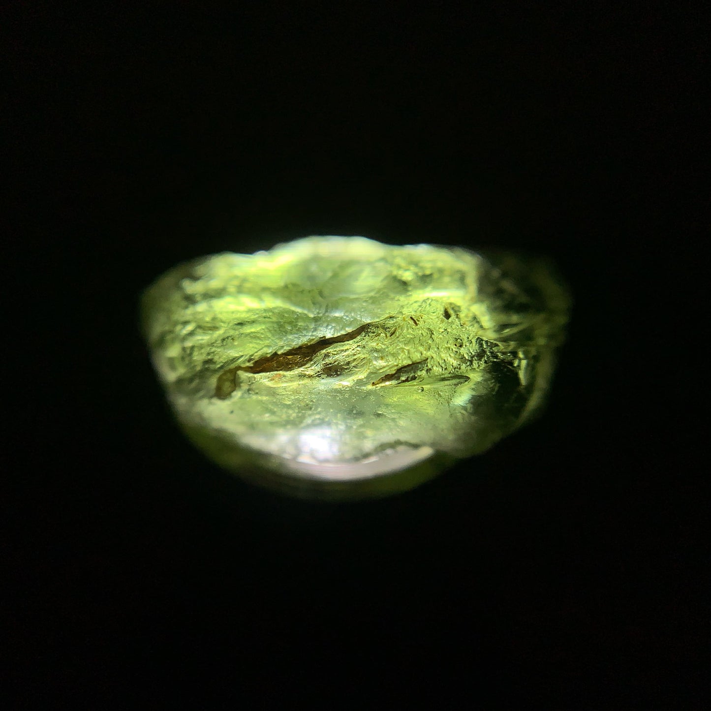 Macro shot of a raw moldavite under the light source
