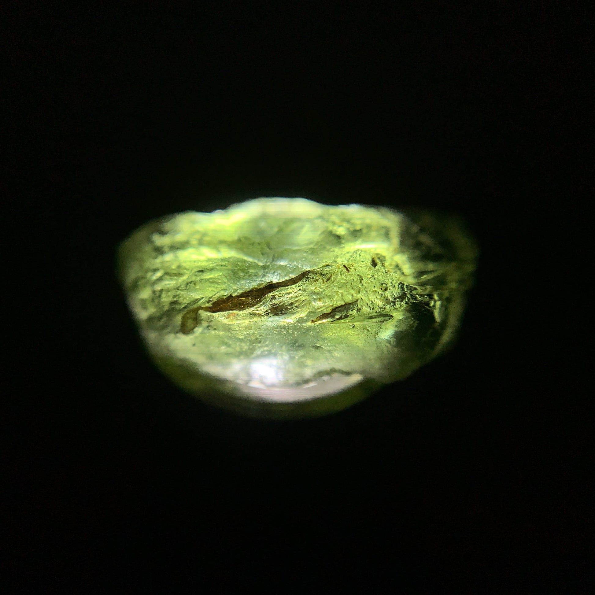 Macro shot of a raw moldavite under the light source