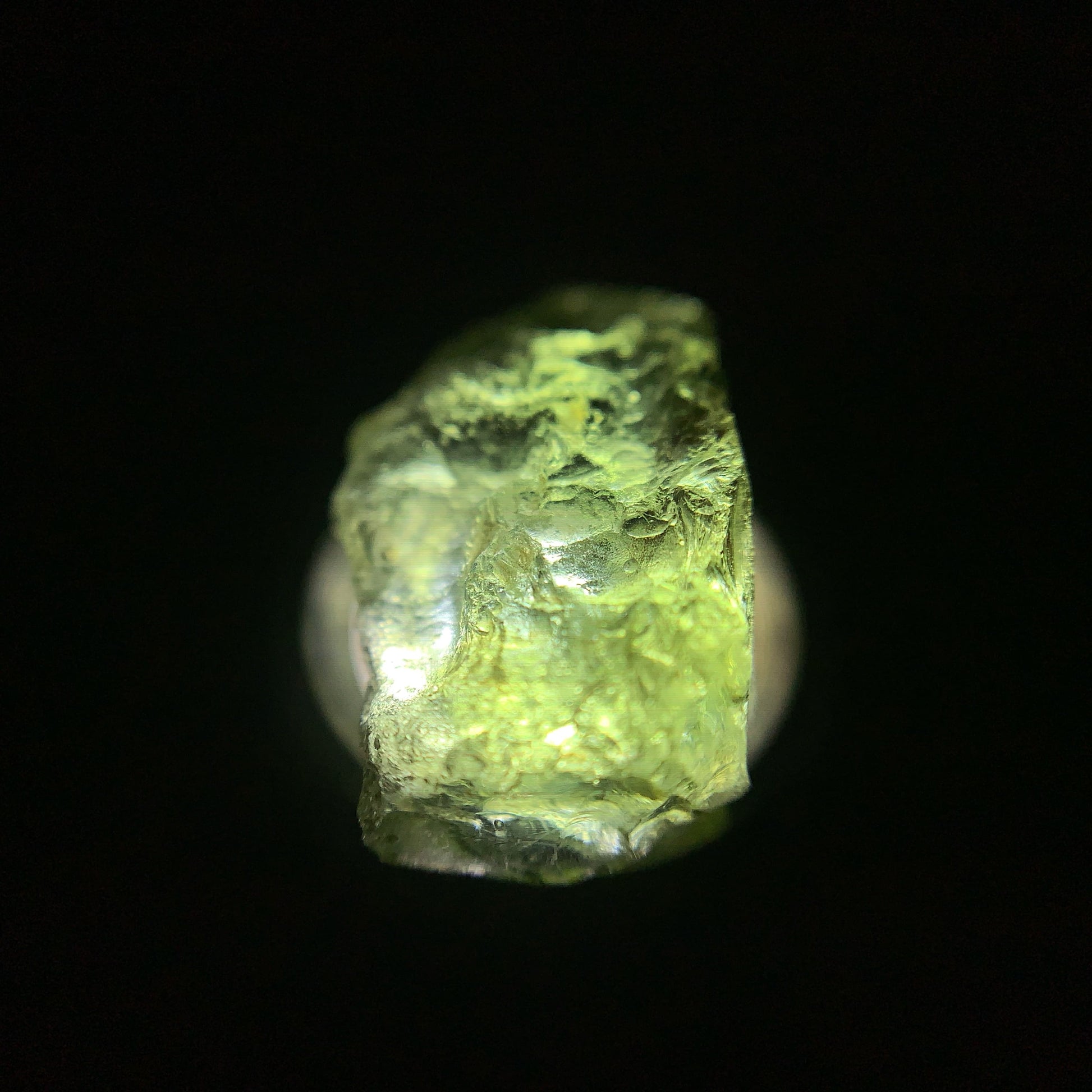 Macro shot of a raw moldavite under the light source