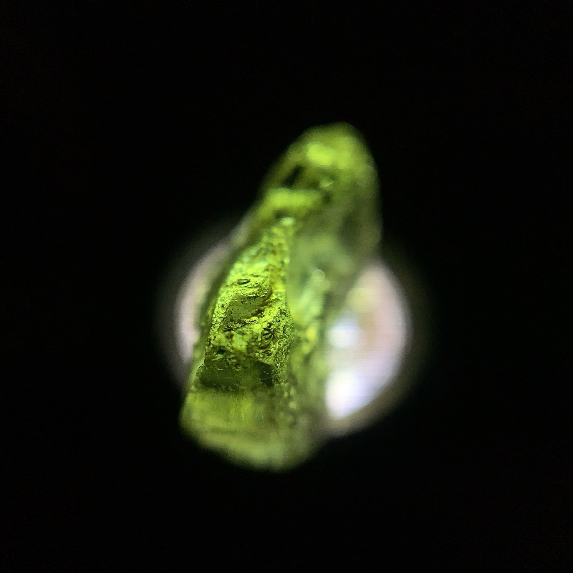 Macro shot of a raw moldavite under the light source