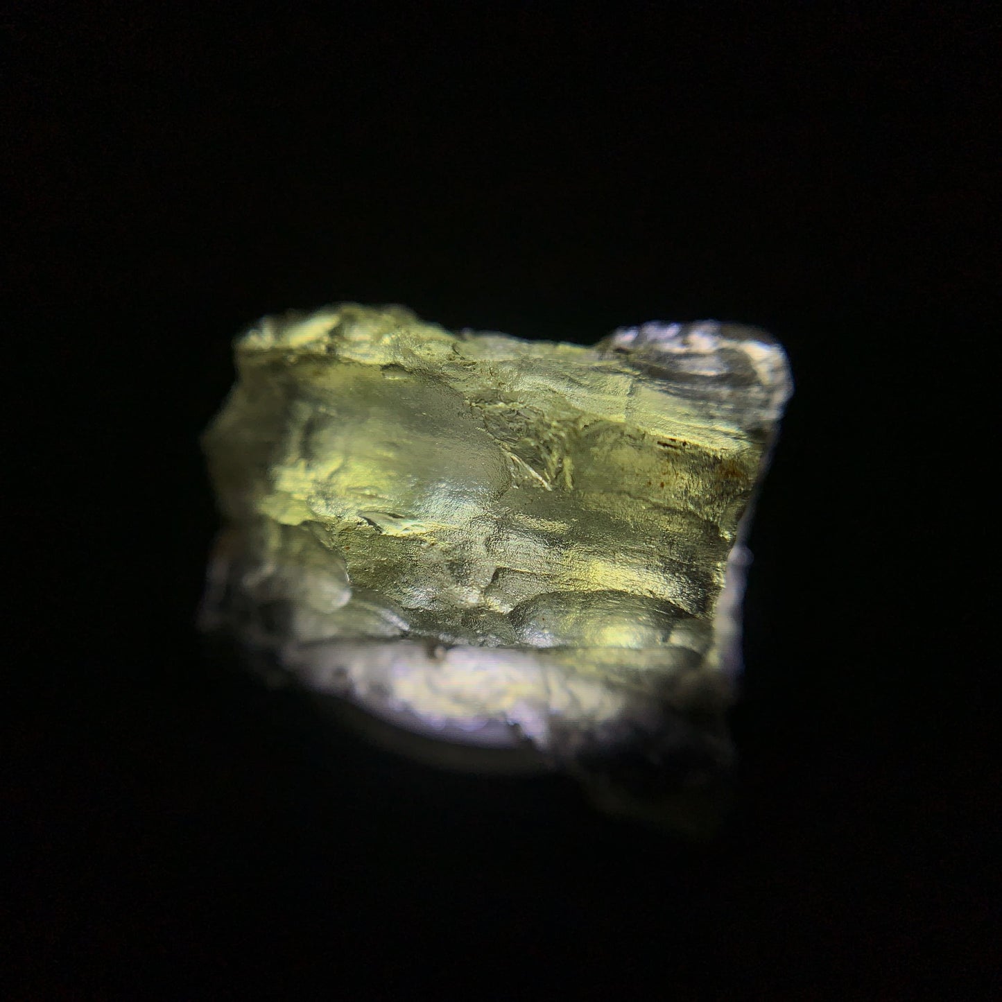 Macro shot of a raw moldavite under the light source