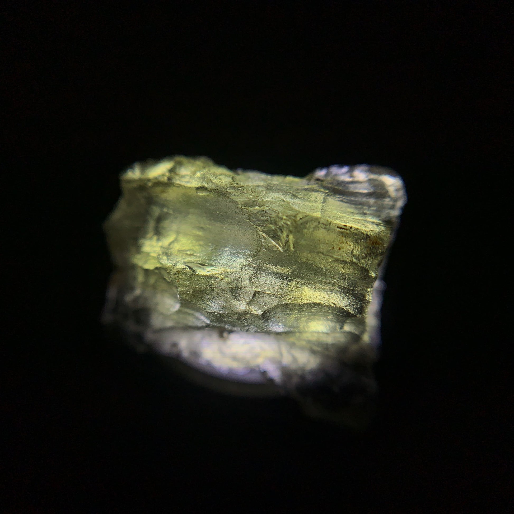 Macro shot of a raw moldavite under the light source