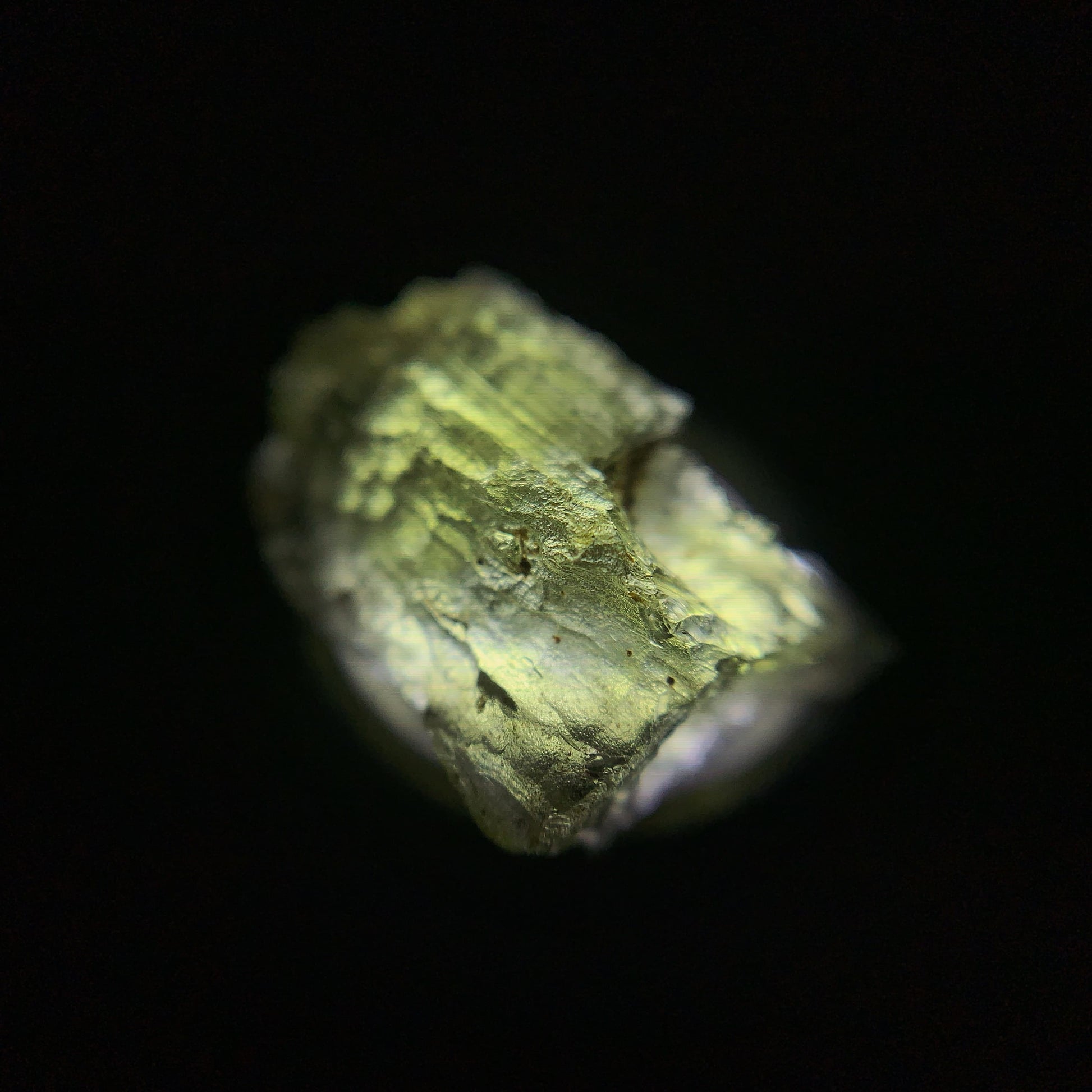 Macro shot of a raw moldavite under the light source