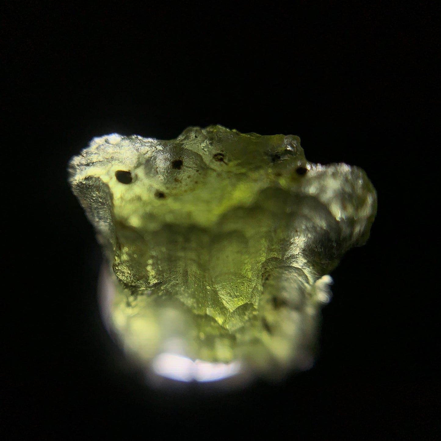 Macro shot of a raw moldavite under the light source