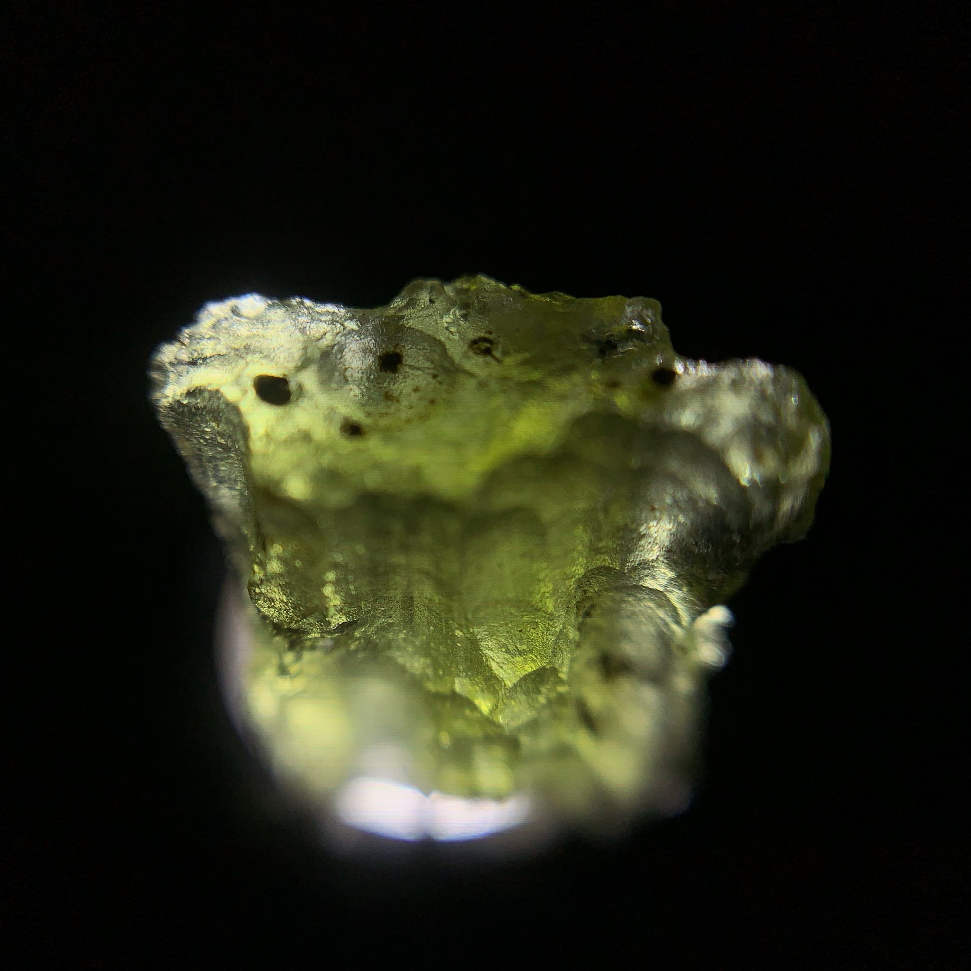 Macro shot of a raw moldavite under the light source