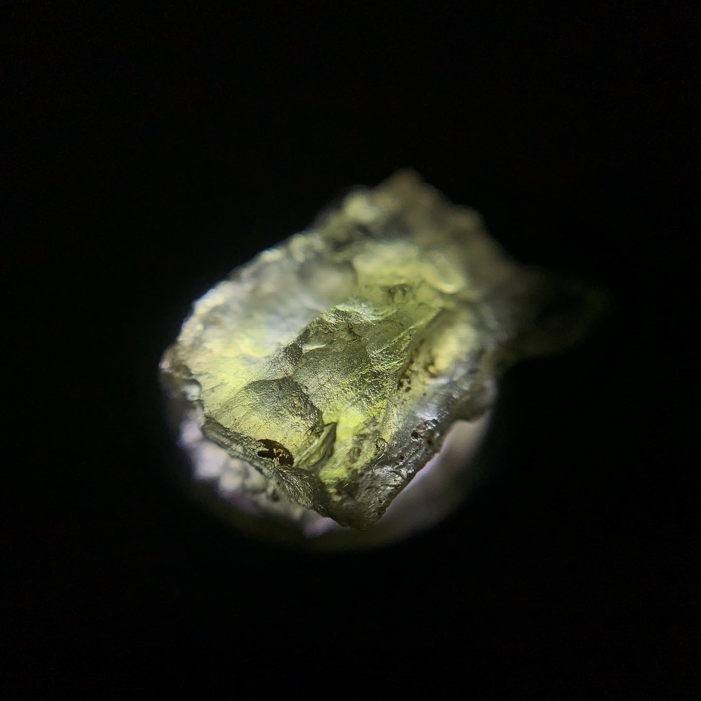 Macro shot of a raw moldavite under the light source
